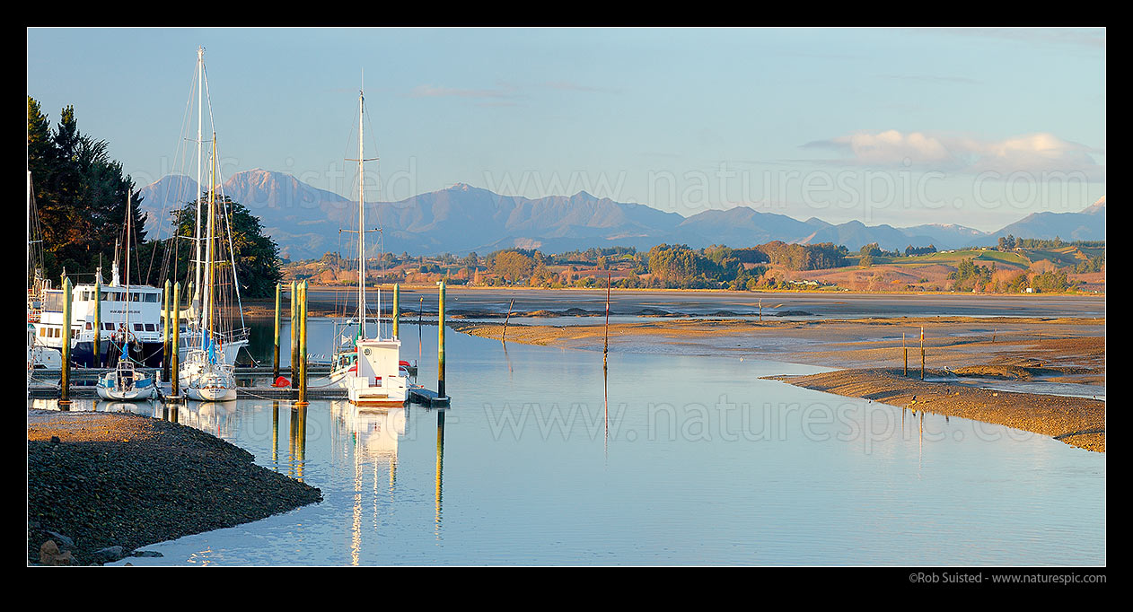 Image of Port Motueka Marina with boats moored in Moutere Inlet at low tide. Richmond Range in distance. Panorama, Motueka, Tasman District, Tasman Region, New Zealand (NZ) stock photo image