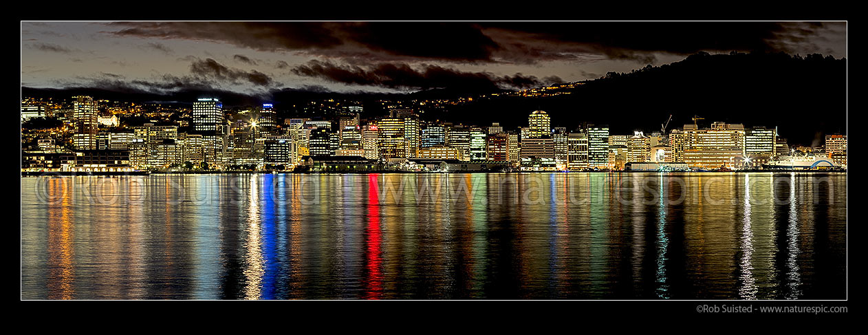 Image of Wellington City CBD skyline and building lights at twilight, reflecting on Lambton Harbour. Panorama, Wellington, Wellington City District, Wellington Region, New Zealand (NZ) stock photo image