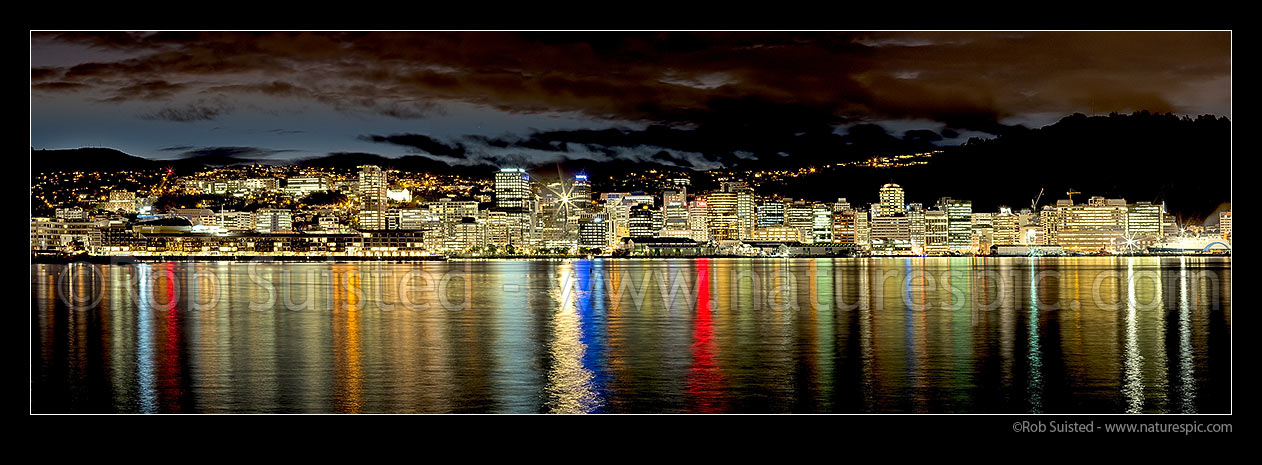 Image of Wellington City CBD skyline and building lights at twilight, reflecting on Lambton Harbour. Panorama, Wellington, Wellington City District, Wellington Region, New Zealand (NZ) stock photo image