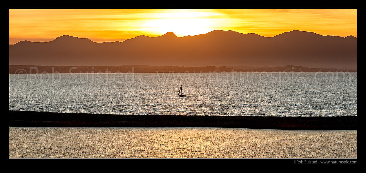 Image of Sailboat sailing on Tasman Bay, beyond The Boulder Bank and Nelson Haven. Kahurangi National Park mountains beyond. Panorama, Nelson, Nelson City District, Nelson Region, New Zealand (NZ) stock photo image