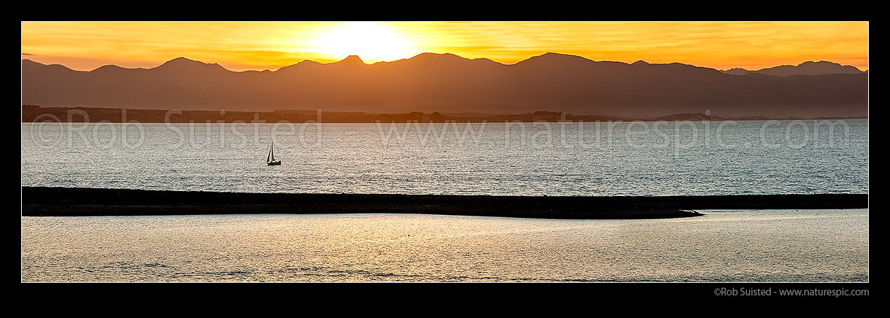 Image of Sailboat sailing on Tasman Bay, beyond The Boulder Bank and Nelson Haven. Kahurangi National Park mountains beyond. Panorama, Nelson, Nelson City District, Nelson Region, New Zealand (NZ) stock photo image