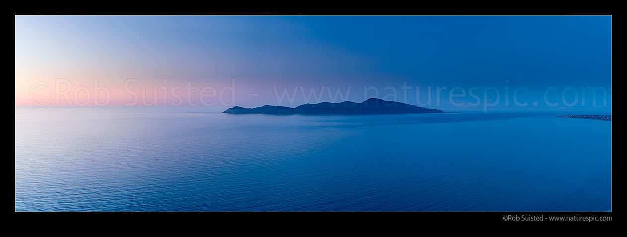 Image of Kapiti Island at dusk. Rauoterangi Channel and Otaheke Strait separate the island 5kms from Paraparaumu Beach. Panorama, Paekakariki, Kapiti Coast District, Wellington Region, New Zealand (NZ) stock photo image