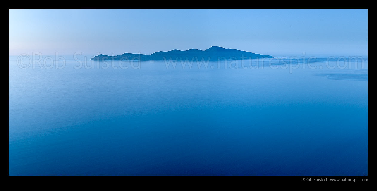 Image of Kapiti Island offshore of Paekakariki and Paraparaumu Beach. Panorama at dusk over Rauoterangi Channel and Otaheke Strait, Paekakariki, Kapiti Coast District, Wellington Region, New Zealand (NZ) stock photo image