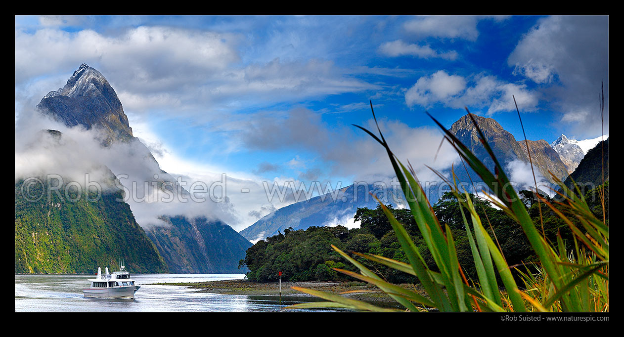 Image of Milford Sound panorama in clearing weather, Fiordland National Park. Small boat below Mitre Peak (1683m) entering Freshwater Basin, Milford Sound, Fiordland National Park, Southland District, Southland Region, New Zealand (NZ) stock photo image