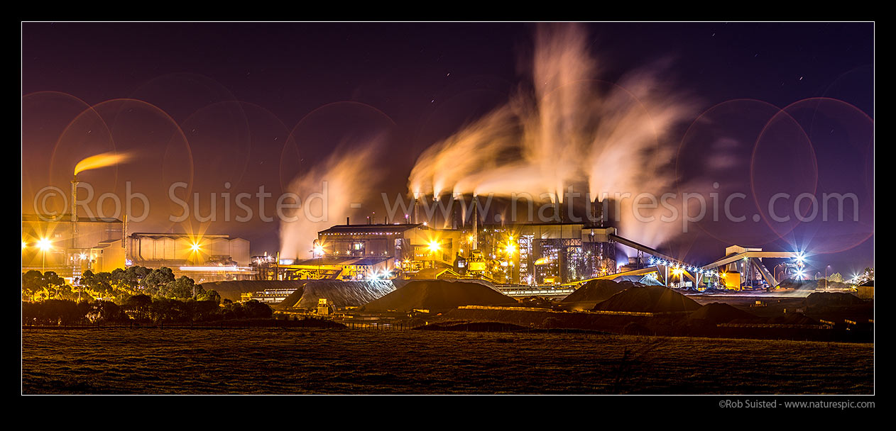 Image of Glenbrook Steel Mill seen at night, producing steel from coastal ironsands ore, a unique utilisation. Steam billowing from stacks. Panorama, Waiuku, Papakura District, Auckland Region, New Zealand (NZ) stock photo image