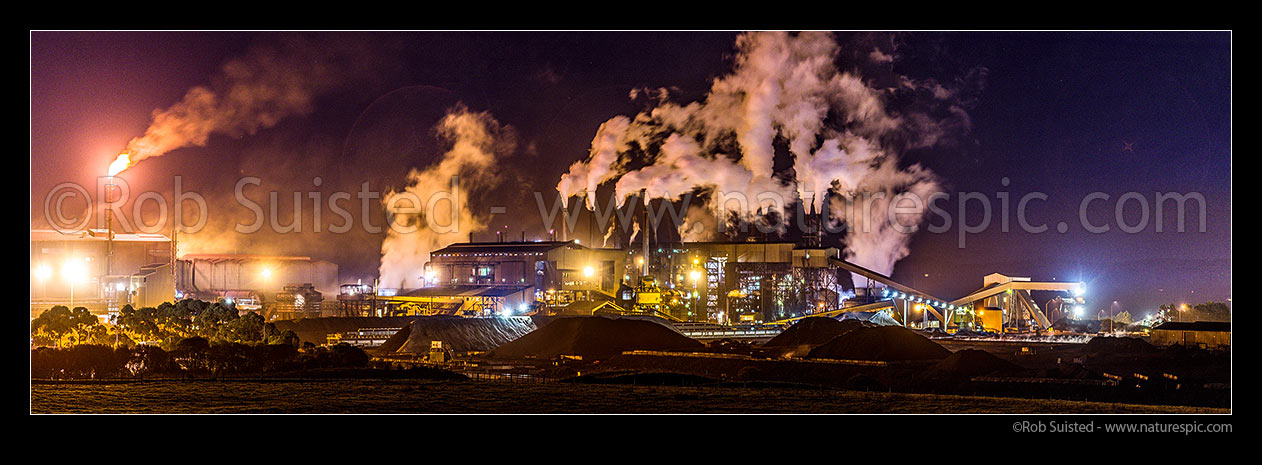 Image of Glenbrook Steel Mill seen at night, producing steel from coastal ironsands ore, a unique utilisation. Steam billowing from stacks. Panorama, Waiuku, Papakura District, Auckland Region, New Zealand (NZ) stock photo image