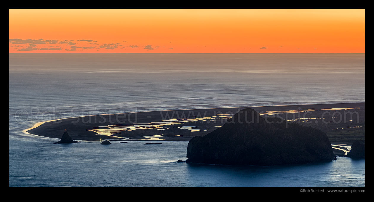 Image of Whatipu Beach and Manukau Harbour entrance. Ninepin Rock light far left and Paratutae Island right. Dune lakes glistening at dusk, Whatipu, Waitakere City District, Auckland Region, New Zealand (NZ) stock photo image