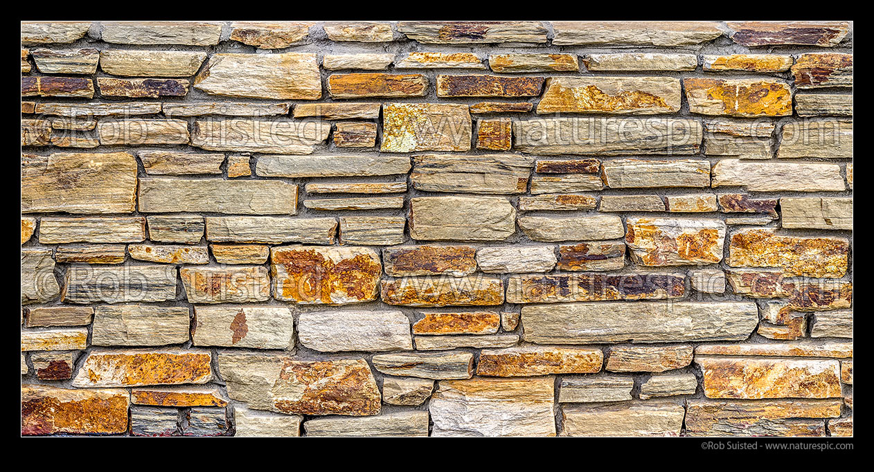 Image of Schist rock wall panorama. Schist rock layered into decorative stone wall. Red schist, New Zealand (NZ) stock photo image