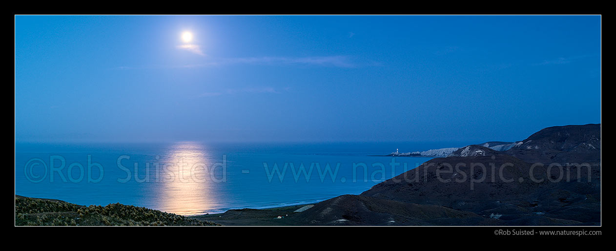 Image of Full moon rising over Clifford Bay and Cape Campbell lighthouse. Twilight panorama, Clifford Bay, Marlborough District, Marlborough Region, New Zealand (NZ) stock photo image