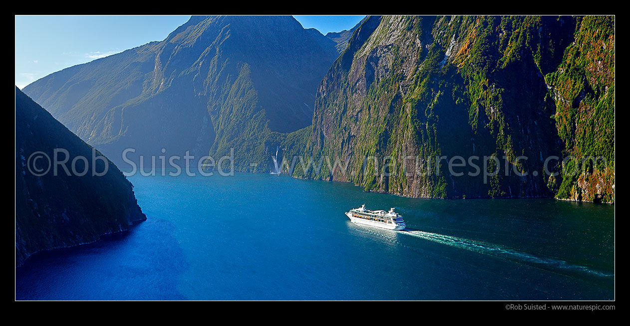 Image of Milford Sound with cruise ship nearing Stirling Falls (151m). Piopiotahi. Panorama, Fiordland National Park, Southland District, Southland Region, New Zealand (NZ) stock photo image