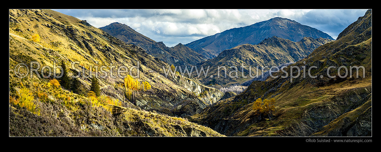 Image of Shotover River valley near historic Skippers township. Sainsbury Huts centre and The Branches Road visible at left. Silverhorn Peak (1749m) above. Autumn panorama, Skippers, Queenstown Lakes District, Otago Region, New Zealand (NZ) stock photo image