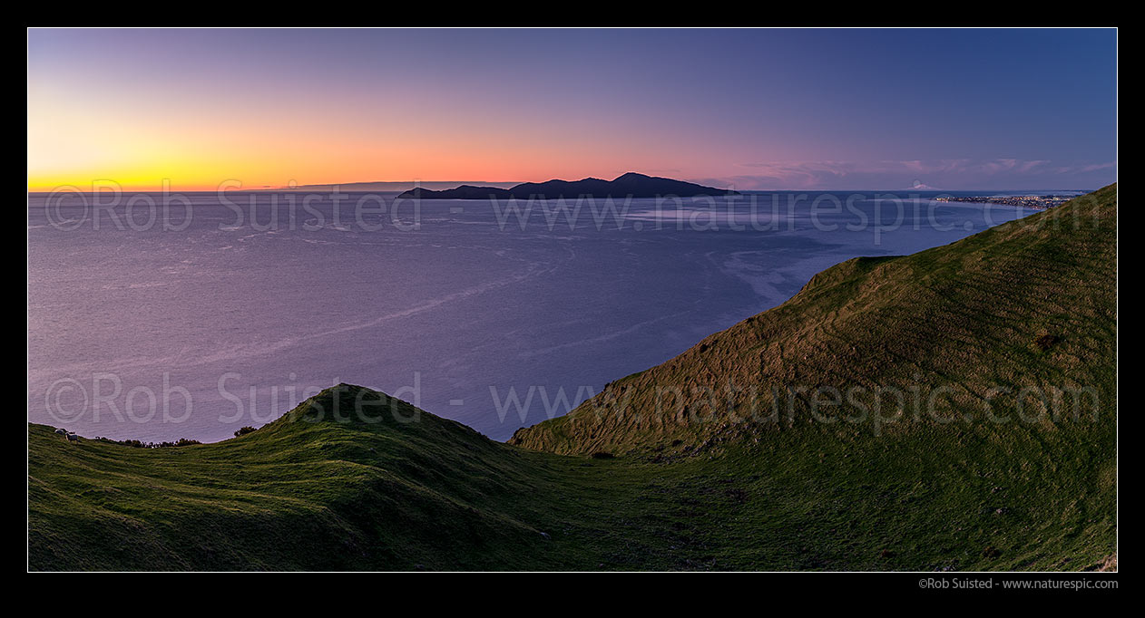 Image of Kapiti Island at sunset, separated at sunset by Rauoterangi Channel and Otaheke Strait from Paraparaumu town and Mt Ruapehu at right distance. Panorama, Paekakariki, Kapiti Coast District, Wellington Region, New Zealand (NZ) stock photo image