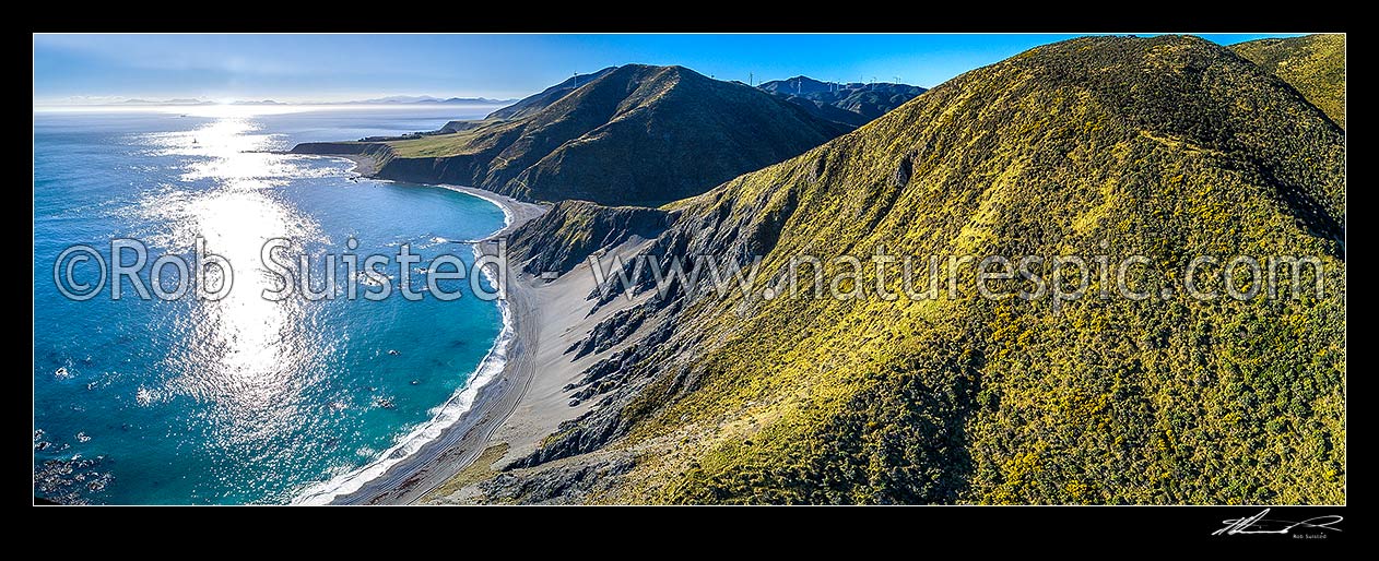 Image of Wellington South Coast. Long Bay beach below, Tongue Point and Karori Rock light left, with South Island beyond over Cook Strait. West Wind turbine farm at right. Aerial panorama, Wellington South Coast, Wellington City District, Wellington Region, New Zealand (NZ) stock photo image