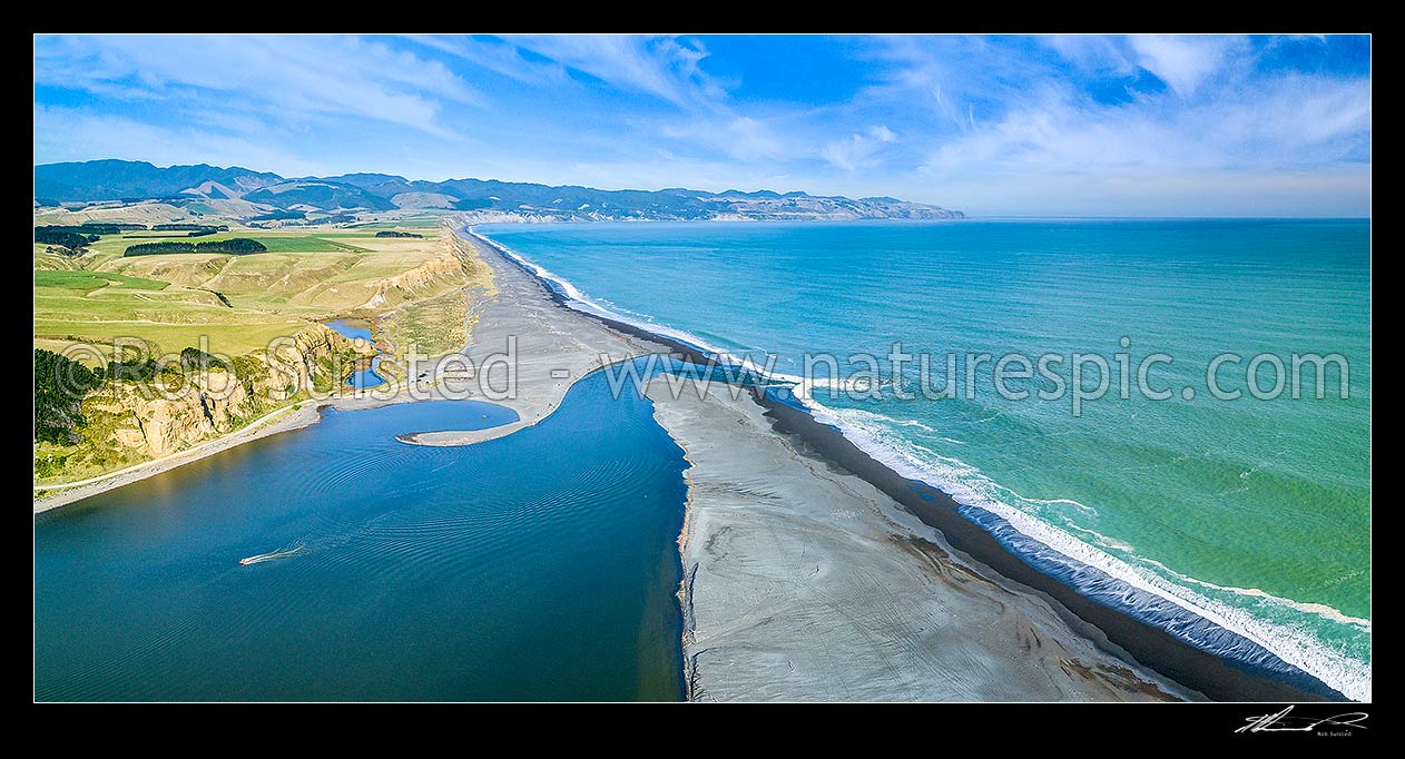 Image of Lake Ferry (Onoke) and outlet into Palliser Bay. Looking along Whangaimoana Beach towards the Aorangi Ranges behind. Cape Palliser centre distance. Aerial panorama, Lake Ferry, South Wairarapa District, Wellington Region, New Zealand (NZ) stock photo image