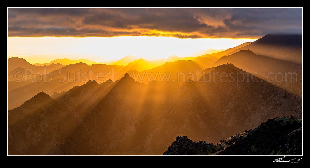 Image of Hodder River Valley sunrise, with dramatic crepuscular sun rays illuminating ridgelines on Camden Station. Dramatic panorama, Awatere Valley, Marlborough District, Marlborough Region, New Zealand (NZ) stock photo image