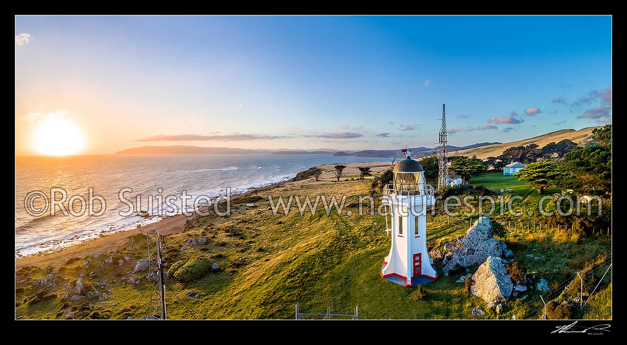 Image of Baring Head Lighthouse and associated buildings at sunset. Fitzroy Bay and Wellington Harbour entrance behind. Aerial panorama. East Harbour Regional Park, Baring Head, Hutt City District, Wellington Region, New Zealand (NZ) stock photo image