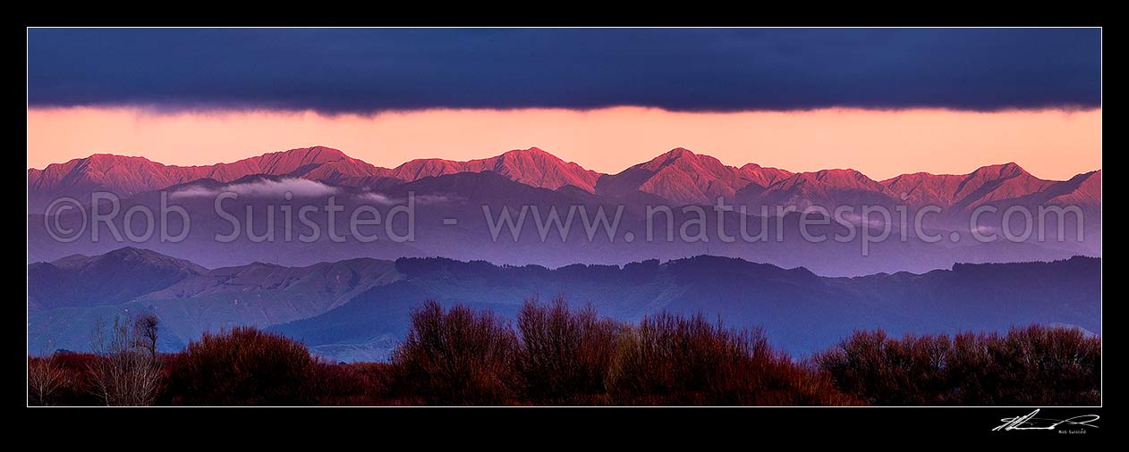 Image of Tararua Ranges seen at dusk with the last light of day lighting the main range. Tararua Forest Park. Seen from near Foxton. Panorama, Foxton, Horowhenua District, Manawatu-Wanganui Region, New Zealand (NZ) stock photo image