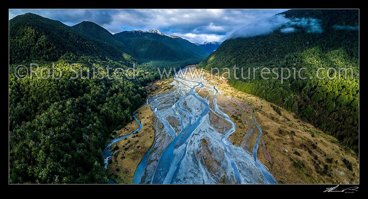 Image of Maruia River flats below Lewis Pass, in breaking weather. Aerial view of braided river flats and beech forest. Mt Mueller (1630m) and Freyberg Range at left, Opera Range and Spenser Mountains distant. Panorama, Maruia Springs, Buller District, West Coast Region, New Zealand (NZ) stock photo image