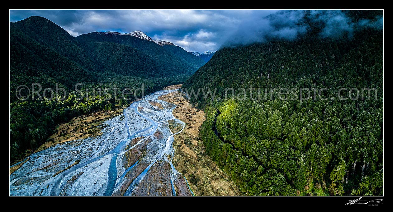 Image of Maruia River flats draining down from Lewis Pass, in breaking weather. Aerial panorama of braided river flats and beech forest. Mt Mueller (1630m) and Freyberg Range at left, Springs Junction, Buller District, West Coast Region, New Zealand (NZ) stock photo image