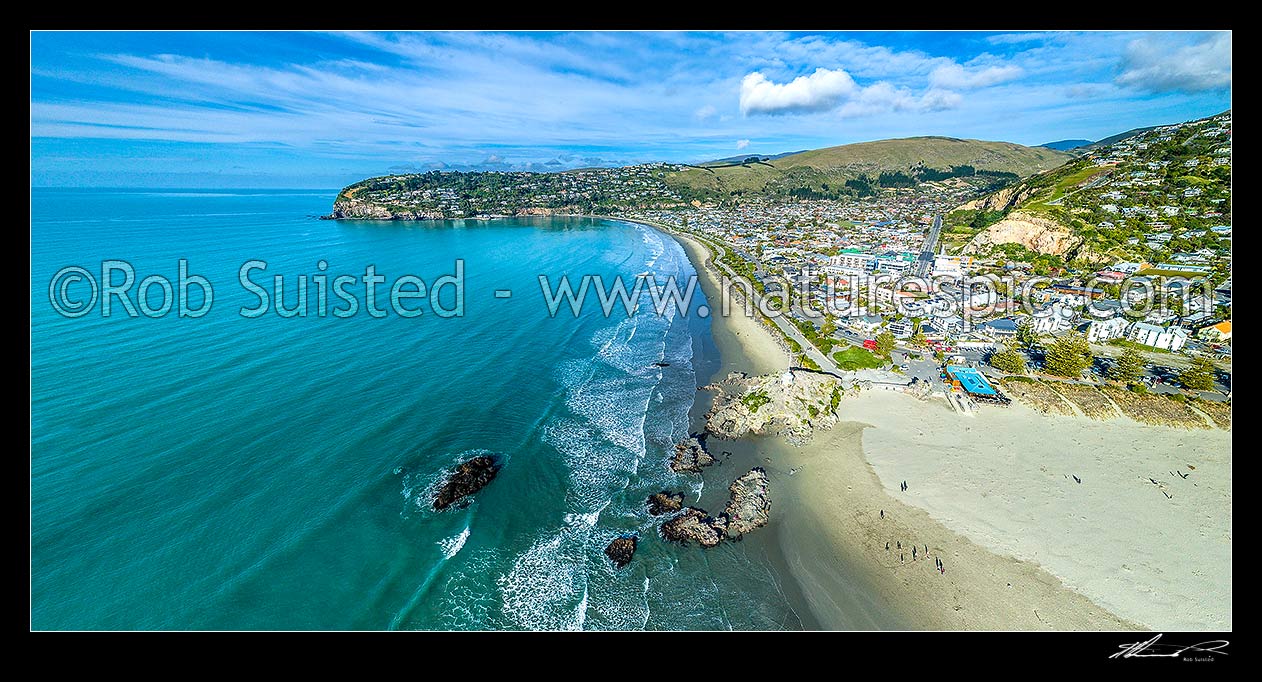 Image of Sumner Beach, with Sumner Head beyond. People enjoying the beach and cave rock on a fine morning. Port Hills above. Aerial panorama, Sumner, Christchurch City District, Canterbury Region, New Zealand (NZ) stock photo image