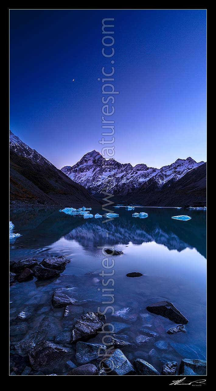 Image of Aoraki / Mount Cook (3754m) at dawn, with moon high above. Hooker Lake and icebergs below. Pre dawn colours. Vertical panorama, Aoraki / Mount Cook National Park, MacKenzie District, Canterbury Region, New Zealand (NZ) stock photo image