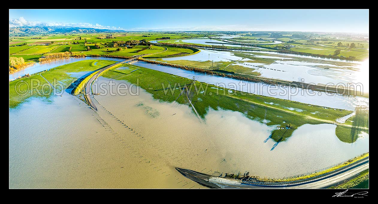 Image of Manawatu River in flood. Looking south across submerged State Highway 56 (SH56) towards Opiki. Aerial panorama view over saturated dairy farmland, Opiki, Horowhenua District, Manawatu-Wanganui Region, New Zealand (NZ) stock photo image