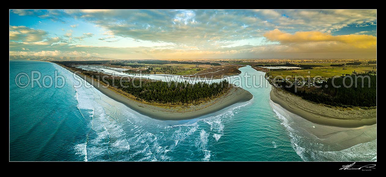 Image of Waimakariri River mouth at sunrise. Port Hills and Christchurch at left, Brooklands Lagoon centre, Kairaki and The Pines Beach at right, Canterbury plains beyond. Aerial panorama, Kaiapoi, Waimakariri District, Canterbury Region, New Zealand (NZ) stock photo image