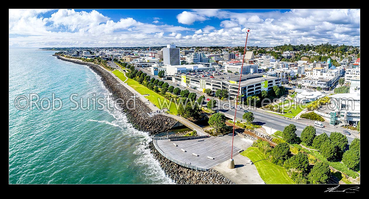 Image of New Plymouth city waterfront, with Len Lye's Wind Wand, a 48m high kinetic sculpture on the foreshore walkway. New Plymouth city CBD beyond. Aerial panorama, New Plymouth, New Plymouth District, Taranaki Region, New Zealand (NZ) stock photo image