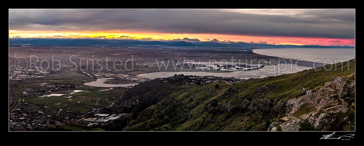 Image of Christchurch City and Canterbury plains on a calm winter evening with snow on the Southern Alps beyond. Heathcote and Avon Estuary, and Pegasus Bay at right. Sunset panorama, Port Hills, Christchurch, Christchurch City District, Canterbury Region, New Zealand (NZ) stock photo image