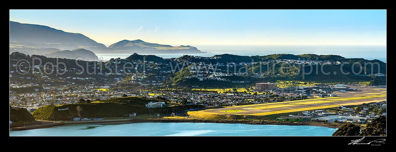 Image of Baring Head and East Harbour Regional Park beyond Wellington harbour entrance, Miramar Peninsula, Wellington International Airport, and Evans Bay. Panorama, Wellington, Wellington City District, Wellington Region, New Zealand (NZ) stock photo image