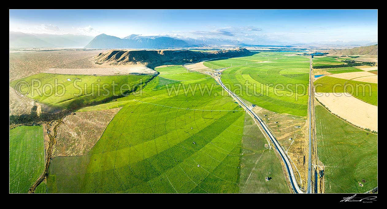 Image of Mackenzie Basin under irrigation. Large pivot irrigators turn the dry alpine glacial outwash plains (left) into lush fertile dairy farms, and change an iconic landscape. Aerial panorama, Twizel, MacKenzie District, Canterbury Region, New Zealand (NZ) stock photo image