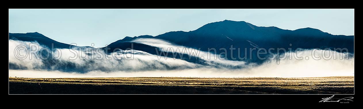 Image of MacKenzie Basin morning mist draped over high country farmland and ranges on a moody dawn. Panorama, Tekapo, MacKenzie District, Canterbury Region, New Zealand (NZ) stock photo image