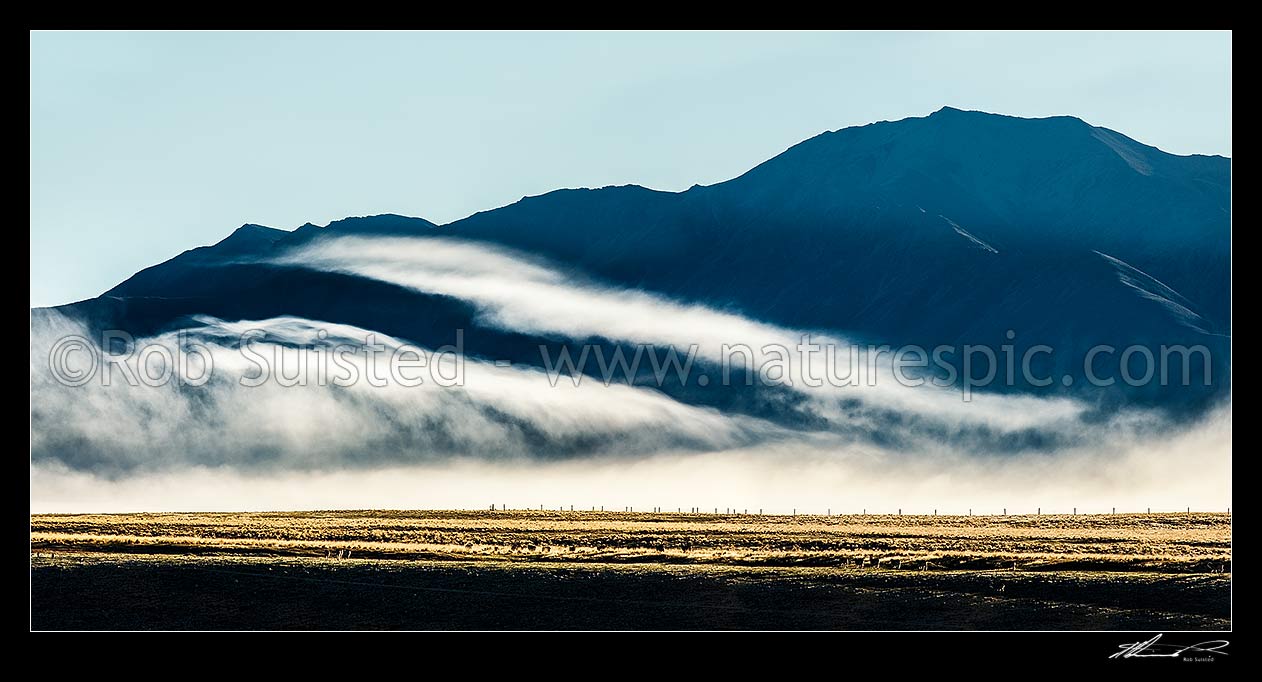 Image of MacKenzie Basin morning mist draped over high country farmland and ranges on a moody dawn. Panorama, Tekapo, MacKenzie District, Canterbury Region, New Zealand (NZ) stock photo image