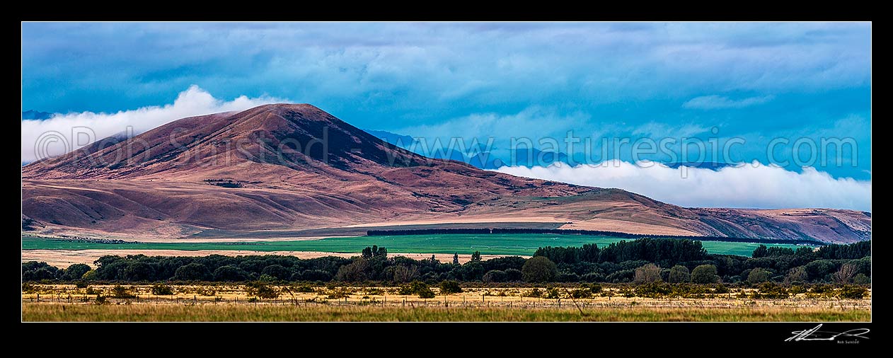 Image of Waitaki headwaters MacKenzie high country in evening over Quailburn irrigated pastures on a moody evening. Panorama, Omarama, Waitaki District, Canterbury Region, New Zealand (NZ) stock photo image