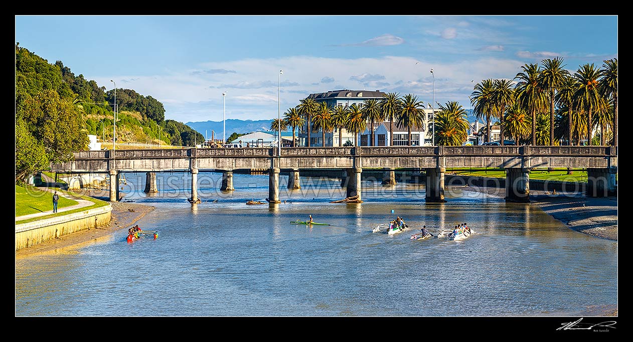 Image of Gisborne City and Turanganui River, with young people practicing Waka Ama outrigger canoe racing near the Gladstone Road Bridge. Panorama, Gisborne City, Gisborne District, Gisborne Region, New Zealand (NZ) stock photo image