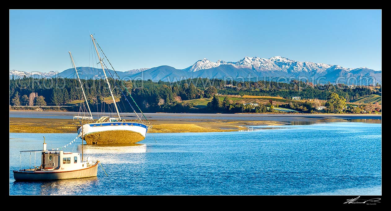 Image of Waimea Inlet at low tide with boats on moorings at Mapua. Kahurangi National Park and Arthur Range beyond. Panorama, Mapua, Tasman District, Tasman Region, New Zealand (NZ) stock photo image