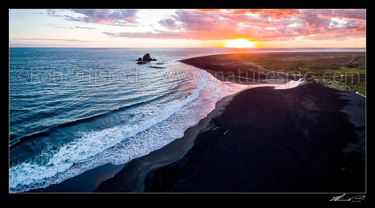 Image of Whatipu Beach, looking west past Ninepin Rock lighthouse (centre left). Aerial view at sunset over the black iron rich sand, and Tasman Sea, Whatipu Beach, Waitakere City District, Auckland Region, New Zealand (NZ) stock photo image