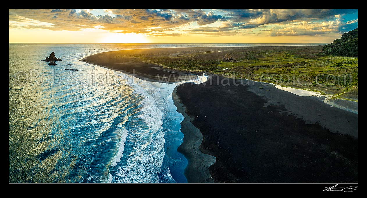 Image of Whatipu Beach sunset over black ironsands.  Ninepin Rock at left, Amphlett Stream centre, and Sargent Point far right. Aerial panorama, Whatipu Beach, Waitakere City District, Auckland Region, New Zealand (NZ) stock photo image