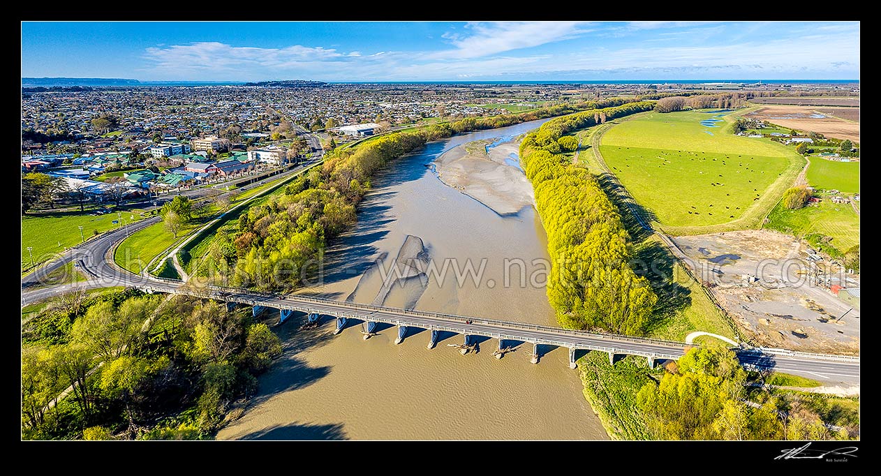 Image of Tutaekuri River discoloured by flooding, at State Highway 50 bridge at Waiohiki. Aerial panorama, with Napier City beyond, Taradale, Napier City District, Hawke's Bay Region, New Zealand (NZ) stock photo image