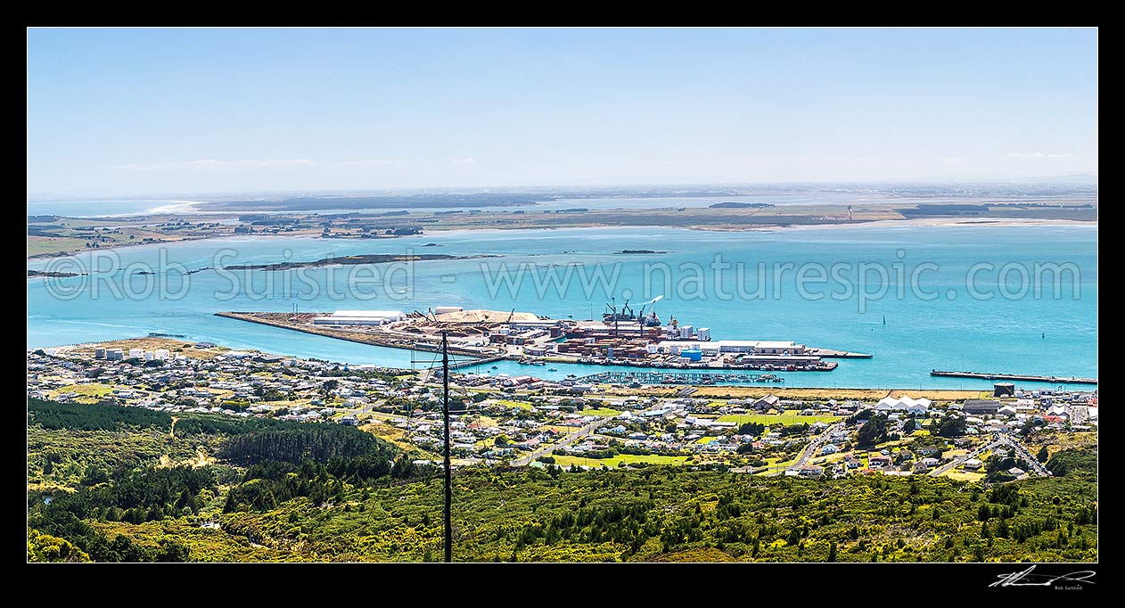 Image of Bluff Harbour with Bluff Port and township, viewed from Bluff Hill. Oreti Beach and New River Estuary distant left, Invercargill City distant right. Panorama, Bluff, Invercargill District, Southland Region, New Zealand (NZ) stock photo image