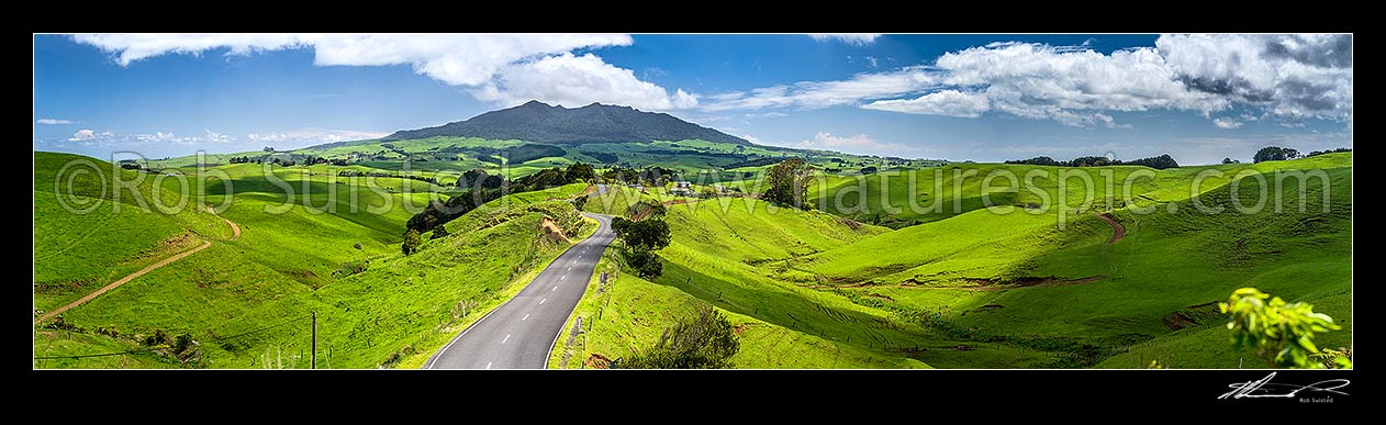 Image of Mount Karioi (756m) high above coastal Waikato farmland. View over lush rural land, road, and pasture, Raglan, Waikato District, Waikato Region, New Zealand (NZ) stock photo image