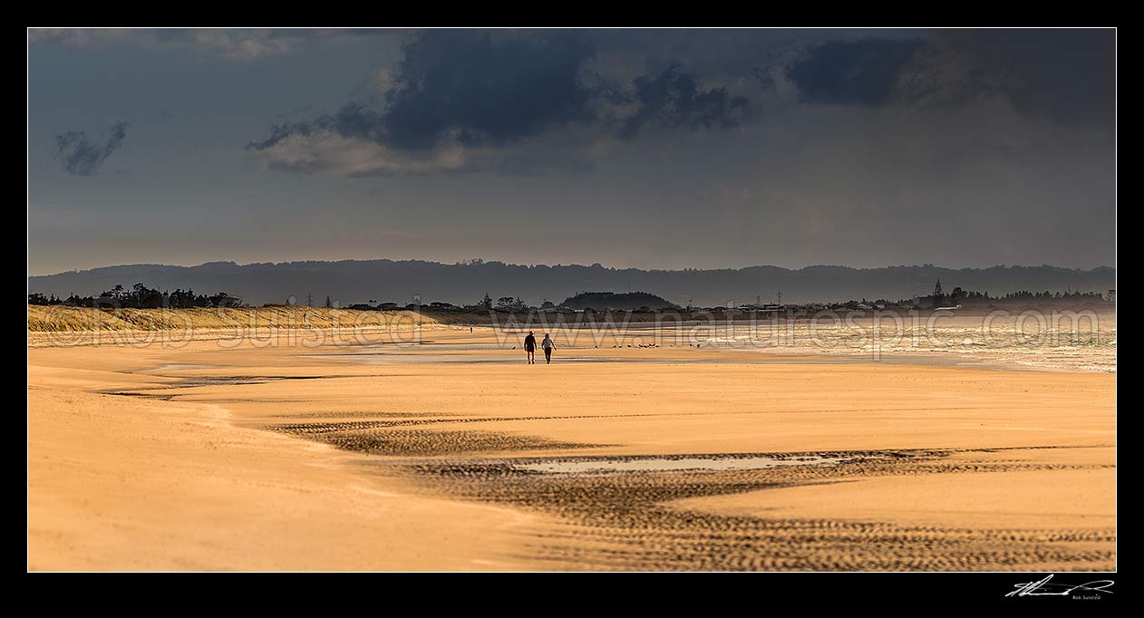 Image of Beach walkers on Ruakaka Beach as the weather changes. Panorama, Ruakaka, Whangarei District, Northland Region, New Zealand (NZ) stock photo image