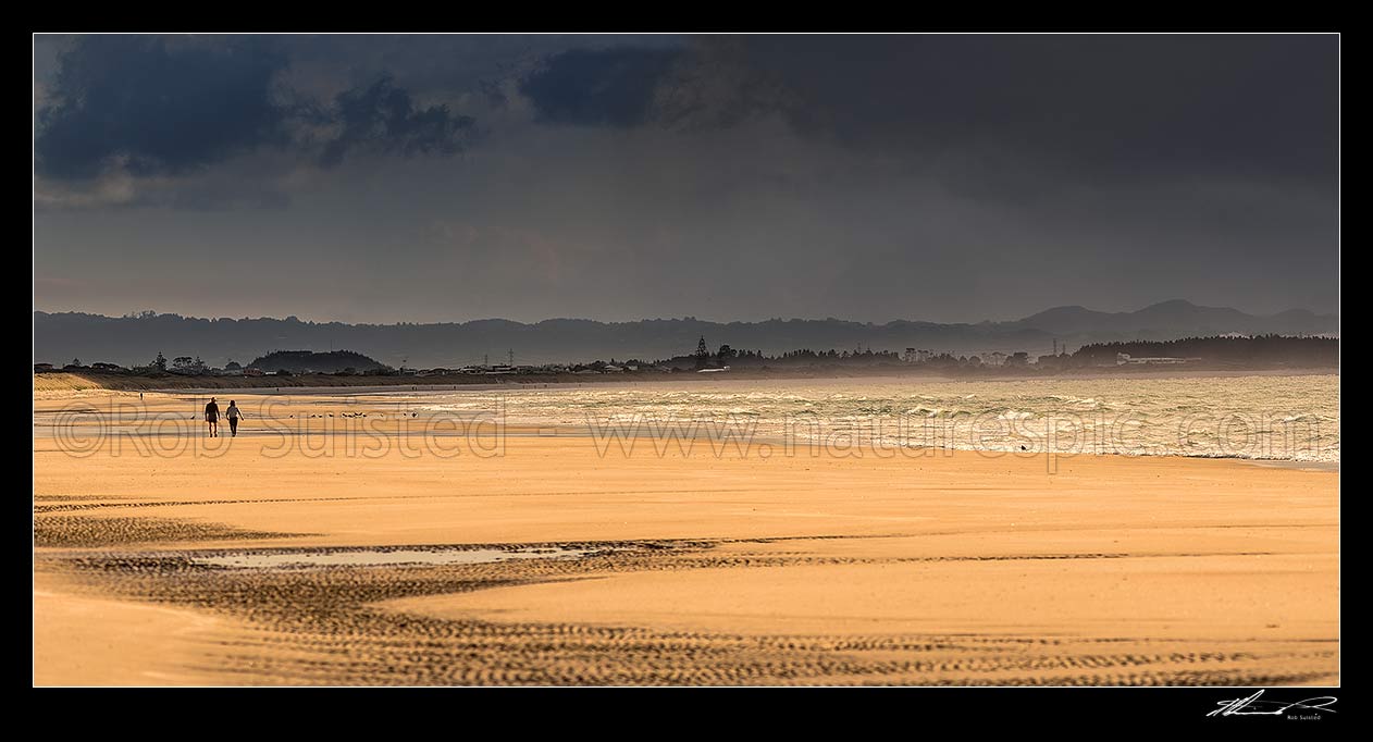 Image of Beach walkers on Ruakaka Beach as the weather changes. Panorama, Ruakaka, Whangarei District, Northland Region, New Zealand (NZ) stock photo image