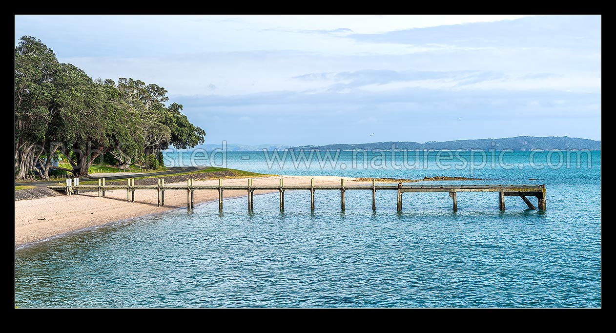 Image of Magazine Bay, Beach and wharf with Waiheke Island beyond across Tamaki Strait. Panorama, Maraetai, Auckland Region, New Zealand (NZ) stock photo image