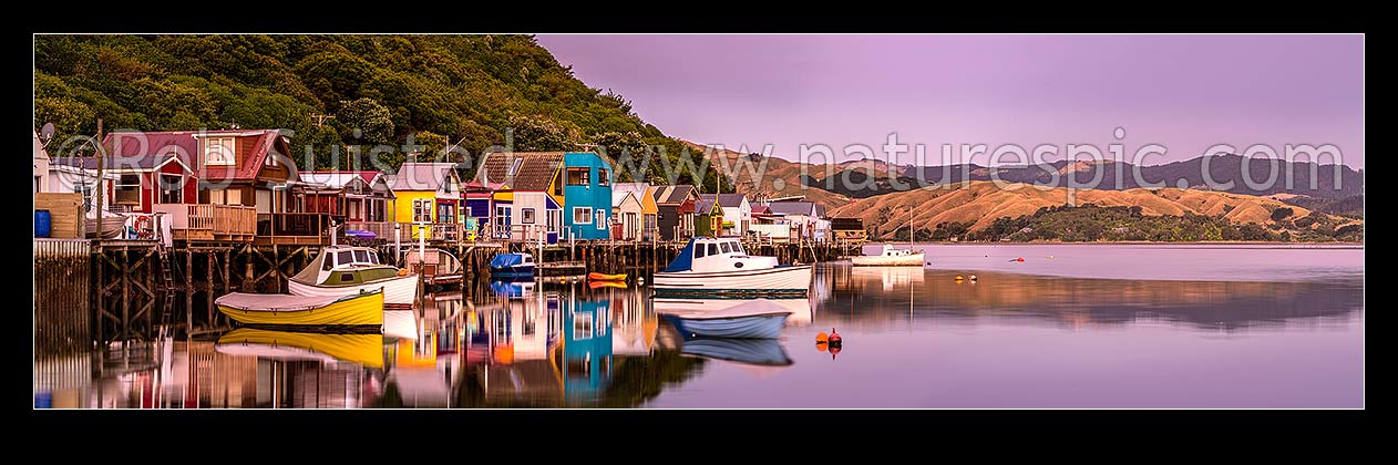 Image of Boatsheds at Mana on the Pauatahanui Arm Inlet of the Porirua Harbour, with boats on moorings. Evening twilight. Panorama, Paremata, Porirua City District, Wellington Region, New Zealand (NZ) stock photo image