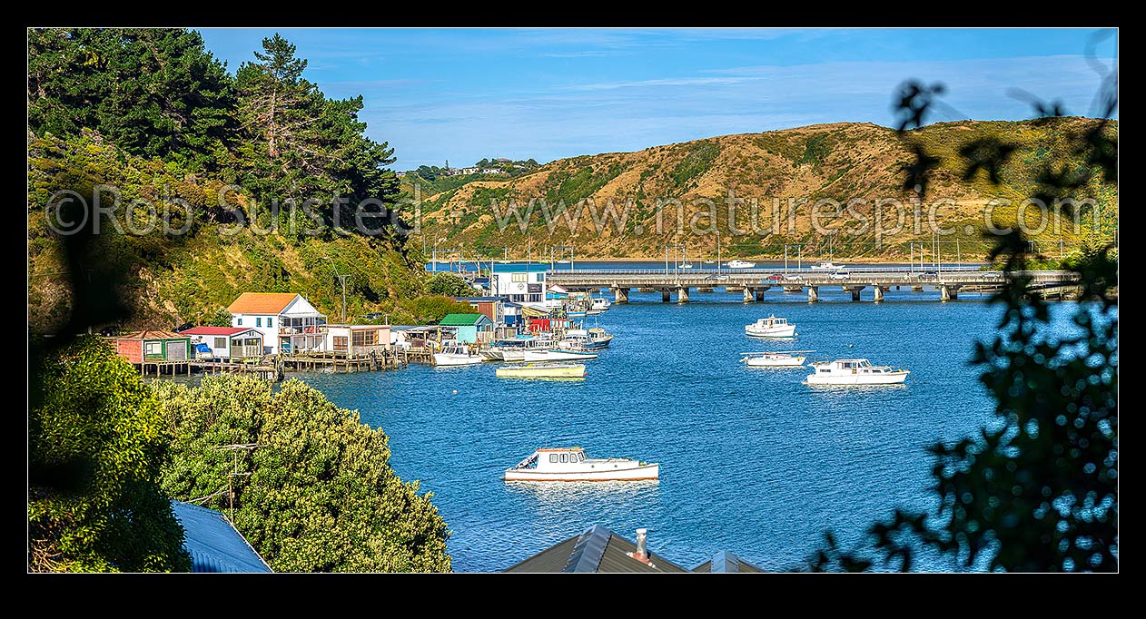 Image of Porirua Harbour with boats moored and boatsheds in Ivey Bay, Pauatahanui Arm. SH1 and railway bridges centre. Panorama, Paremata, Porirua City District, Wellington Region, New Zealand (NZ) stock photo image