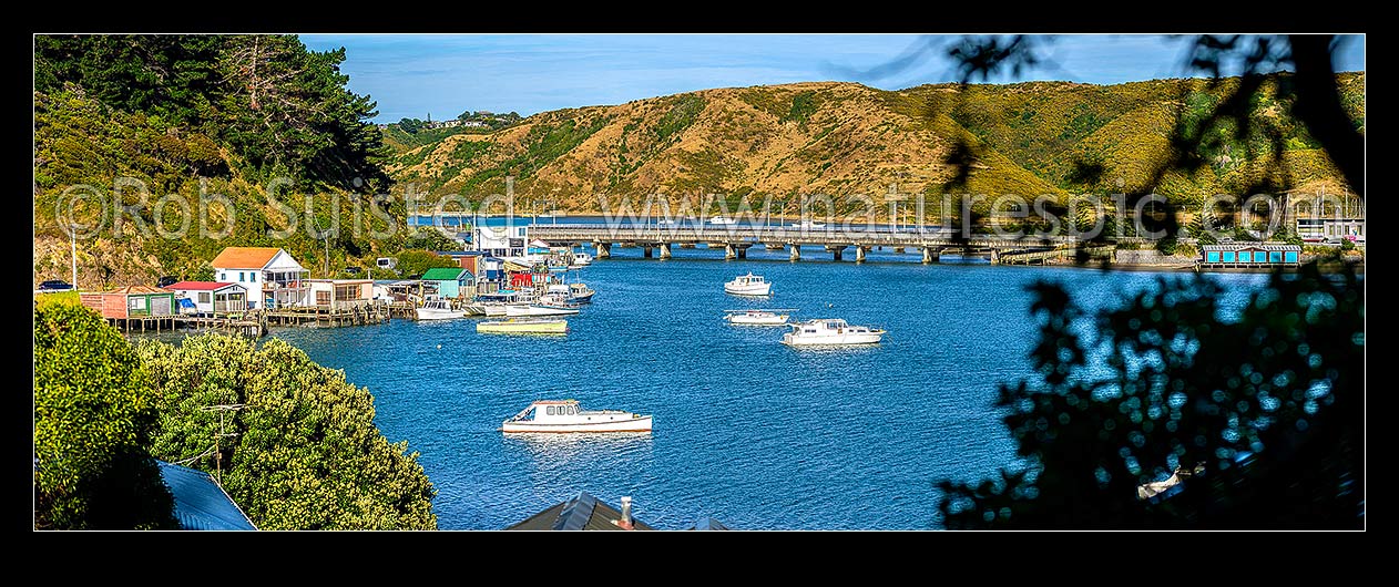 Image of Porirua Harbour with boats moored and boatsheds in Ivey Bay, Pauatahanui Arm. SH1 and railway bridges centre. Panorama, Paremata, Porirua City District, Wellington Region, New Zealand (NZ) stock photo image