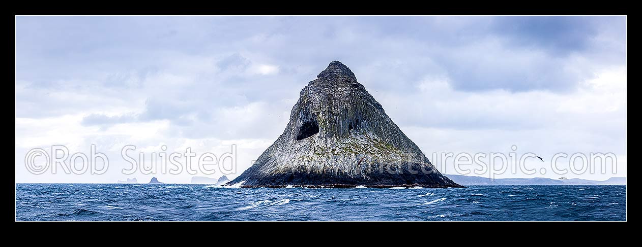 Image of The Pyramid (Tarakoikoia) island, basalt outcrop, with reefs and islands of The Castle and Little Mangere (left) and Pitt Island (right) behind. Panorama, The Pyramid, Chatham Islands District, Chatham Islands Region, New Zealand (NZ) stock photo image