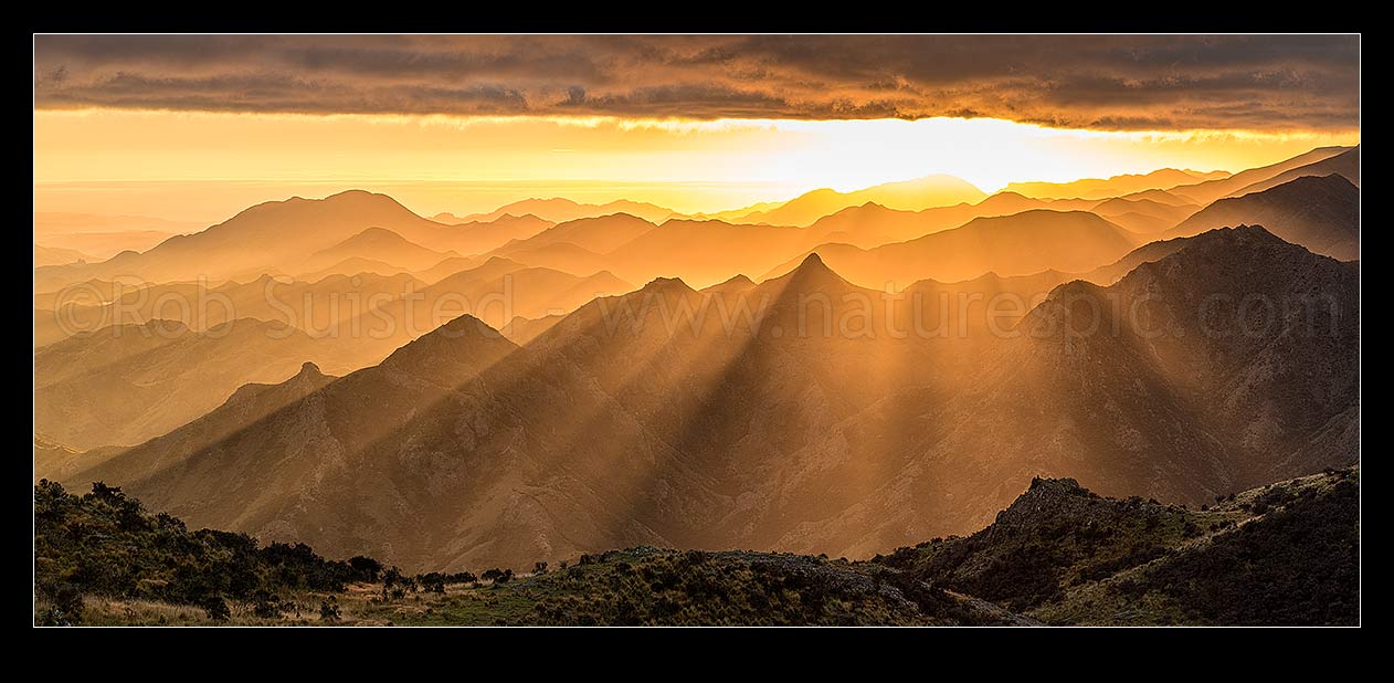 Image of Awatere Valley (left) sunrise, with crepuscular rays of sunlight lighting the Hodder River valley, Gladstone Downs and Camden Stations. Panorama, Awatere Valley, Marlborough District, Marlborough Region, New Zealand (NZ) stock photo image