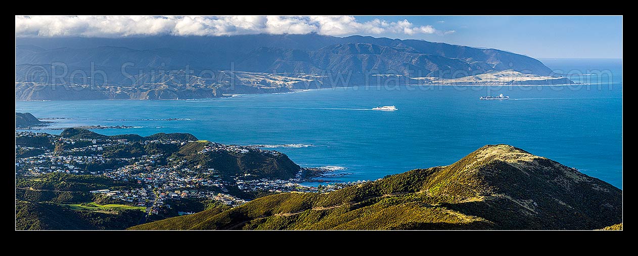 Image of Wellington South Coast and Harbour entrance seen from Te Kopahau Reserve. Pencarrow, Baring and Turakirae Heads behind. Island Bay centre. Panorama, Owhiro Bay, Wellington City District, Wellington Region, New Zealand (NZ) stock photo image